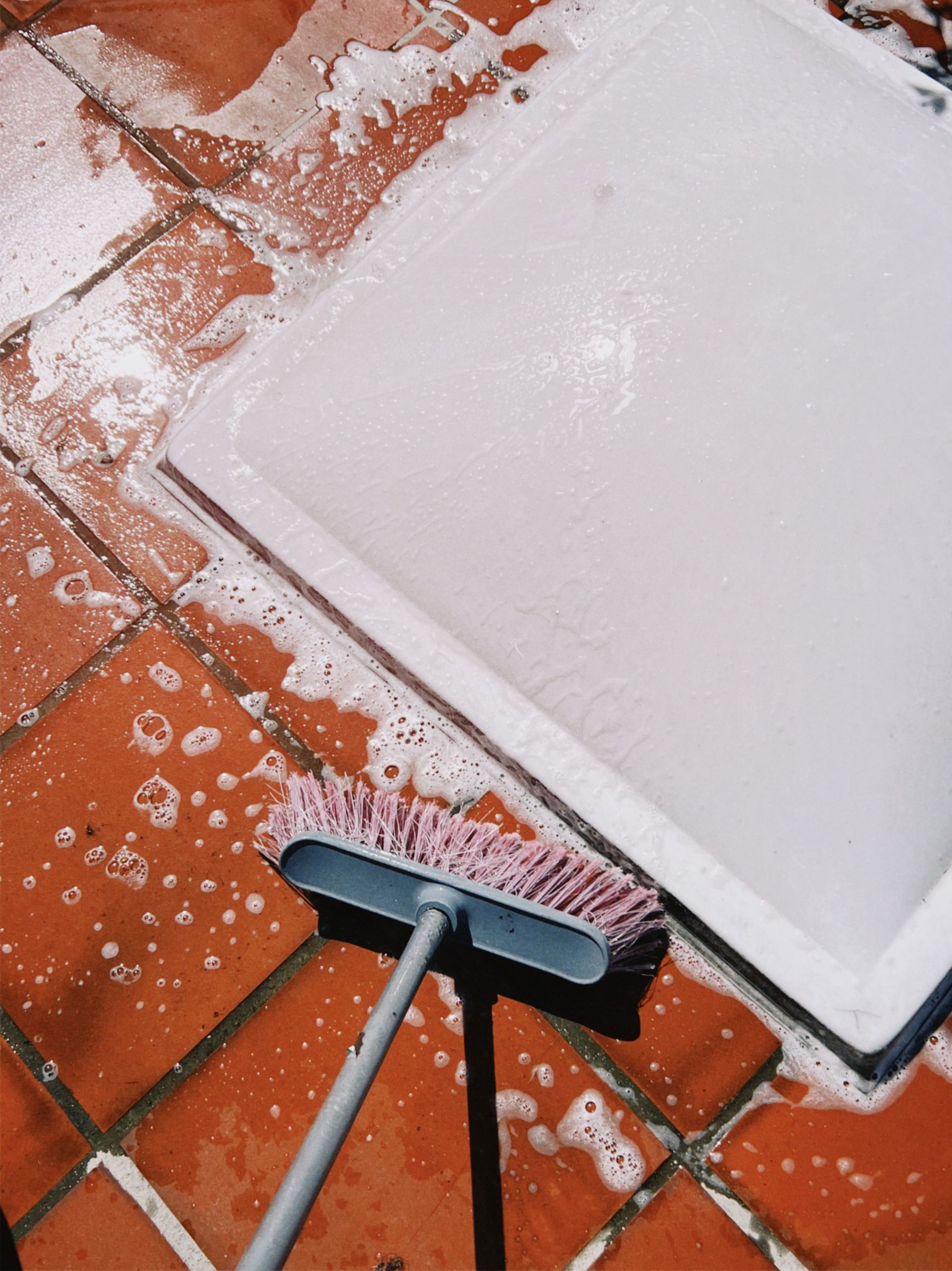 Close-up of soapy tiles being scrubbed. Perfect for cleaning and maintenance themes.